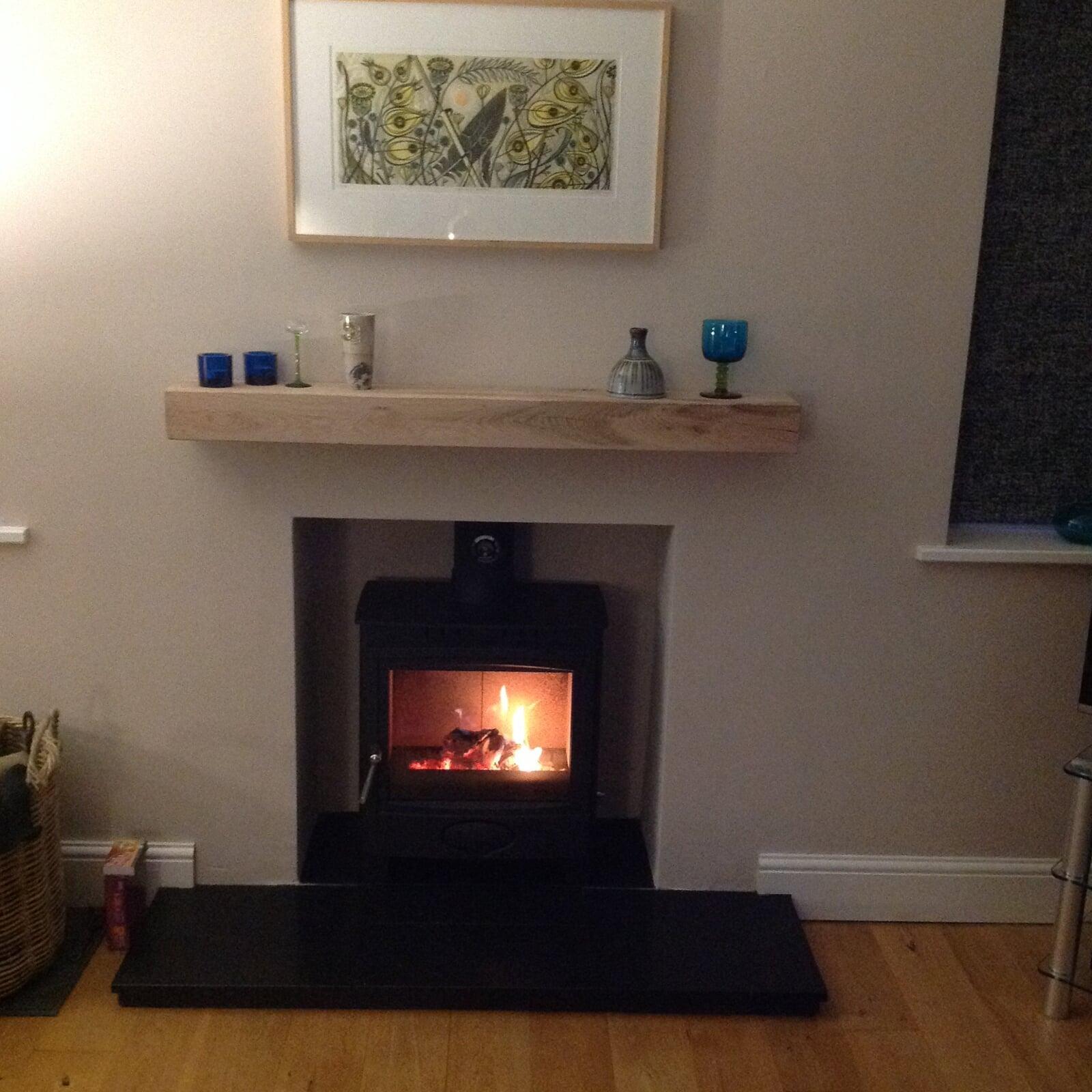 Woodburning stove with rendered chamber- oak beam mantel shelf and granite hearth