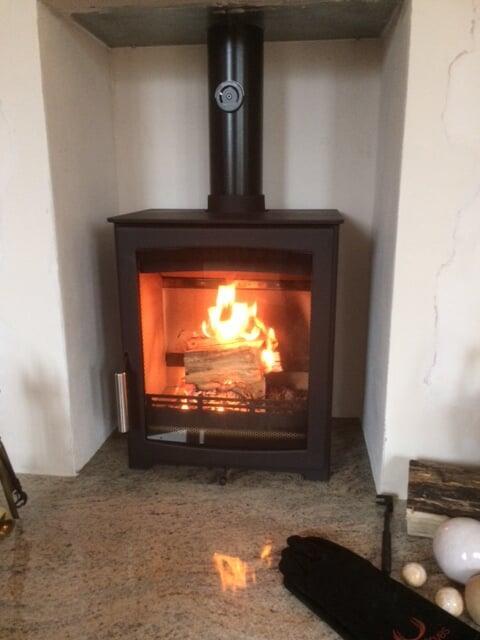 Woodburning stove with rendered chamber and granite hearth